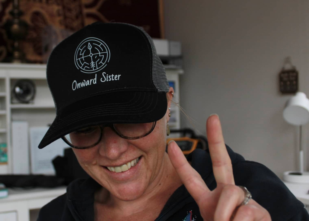 A photo of Sue Evergreen wearing an Onward Sister hat.