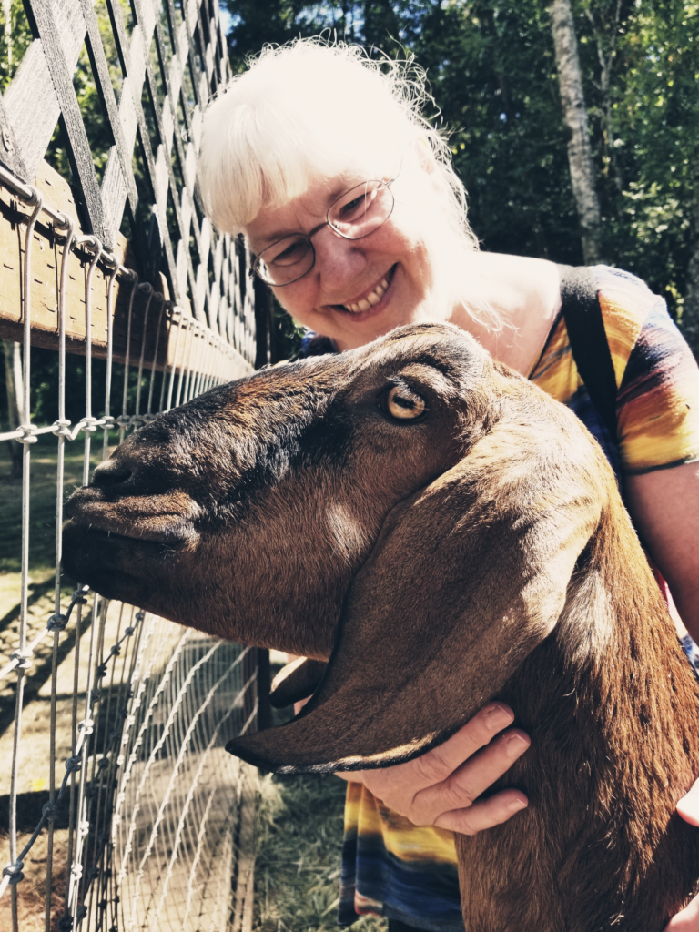 A photo of Sandra with a goat. Photo taken and copyrighted by Sue Evergreen.