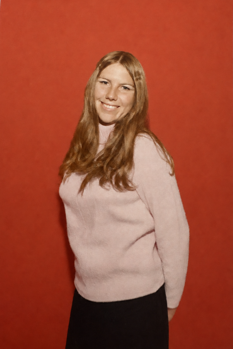 Sandra's graduation photo of her in a pink sweater in front of a red backdrop. Image permissions from Sandra to Onward Sister.
